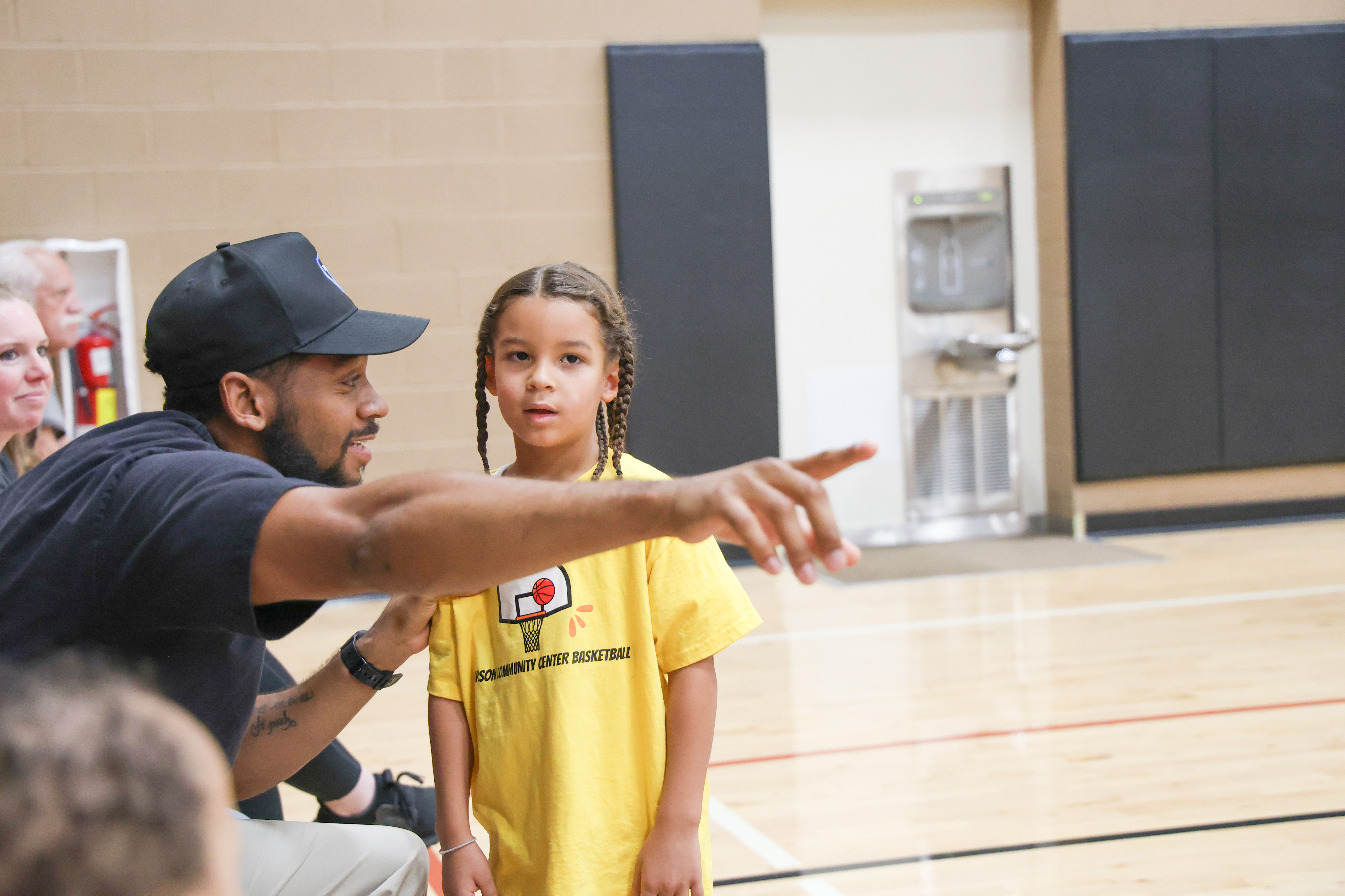 A coach instructing a young basketball player
